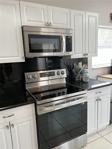 a kitchen with white cabinets and white appliances