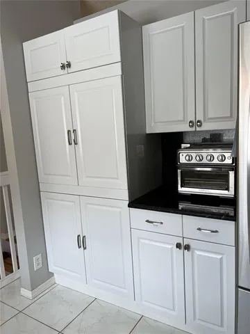 a kitchen with stainless steel appliances kitchen island granite countertop a refrigerator and a stove top oven