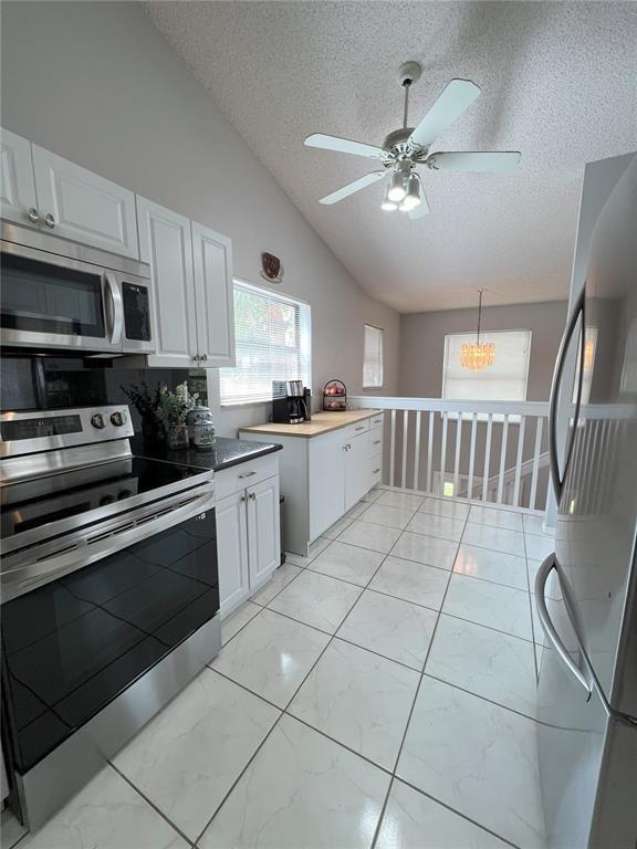 18266 Covina Way, Unit 202 Boca Raton, FL 33498 - Photo 20 of 52 a kitchen with stainless steel appliances a stove a sink a microwave and cabinets
