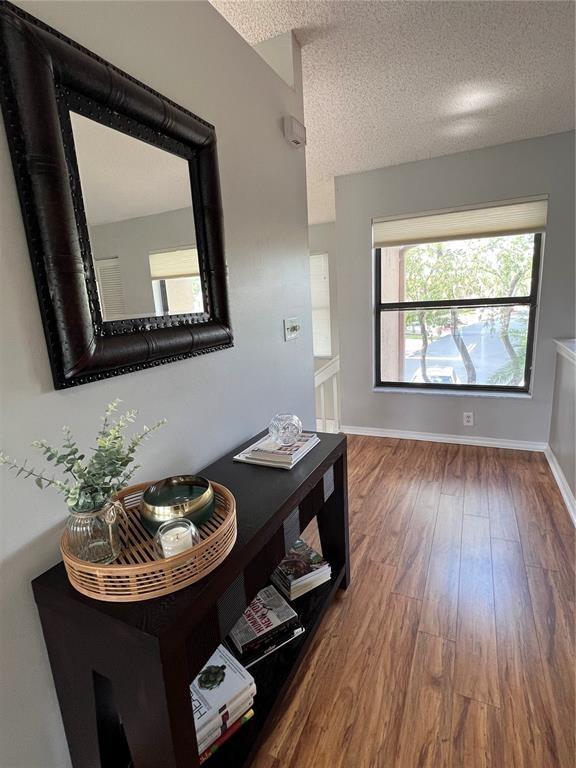 18266 Covina Way, Unit 202 Boca Raton, FL 33498 - Photo 21 of 52 a living room with a dining table wooden floor and a fireplace
