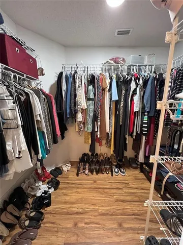 a view of walk in closet with clothes and shoes