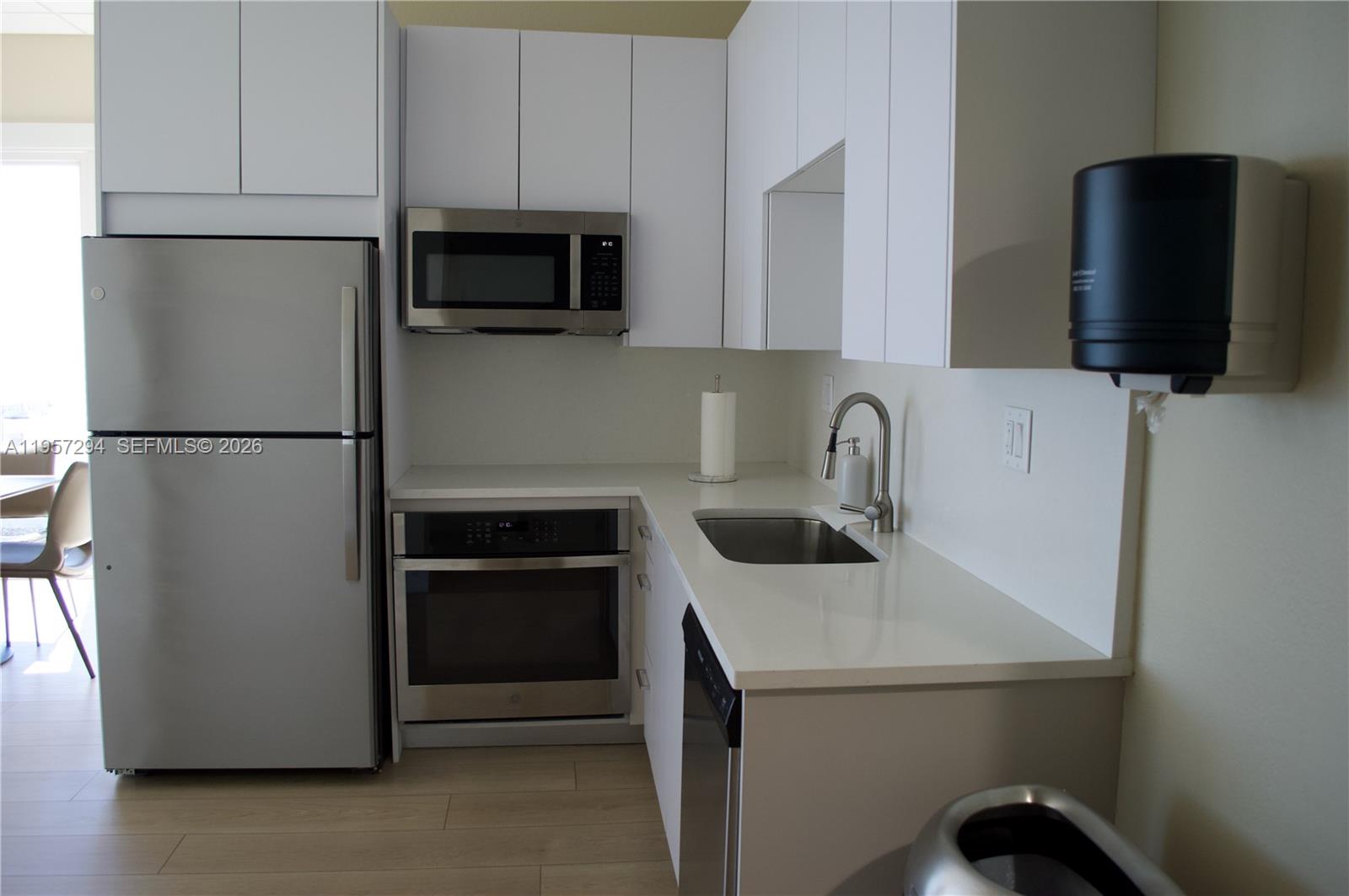 1370 South Ocean Boulevard, Unit 903 Pompano Beach, FL 33062 - Photo 30 of 34 a kitchen with a refrigerator sink and cabinets
