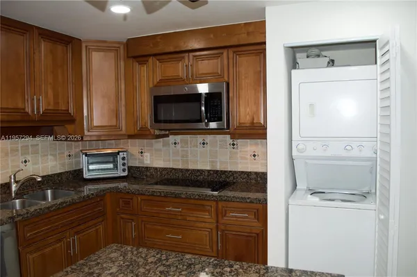 a kitchen with granite countertop a refrigerator stove and microwave