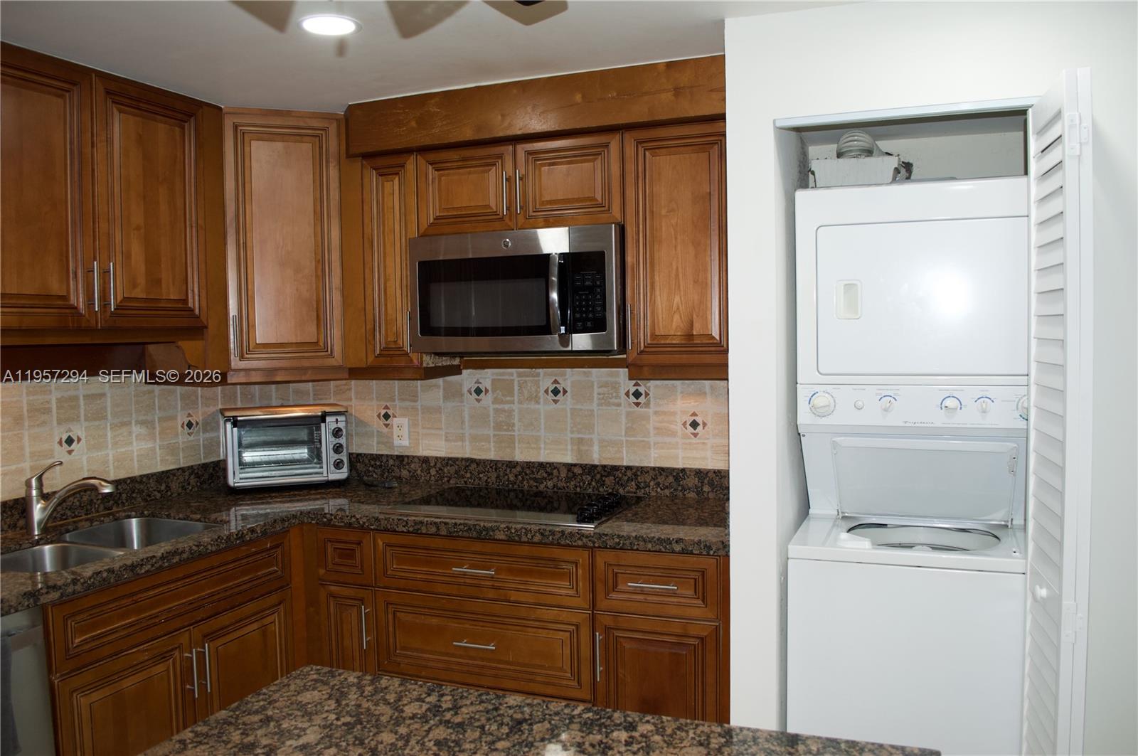 1370 South Ocean Boulevard, Unit 903 Pompano Beach, FL 33062 - Photo 6 of 30 a kitchen with granite countertop a refrigerator stove and microwave