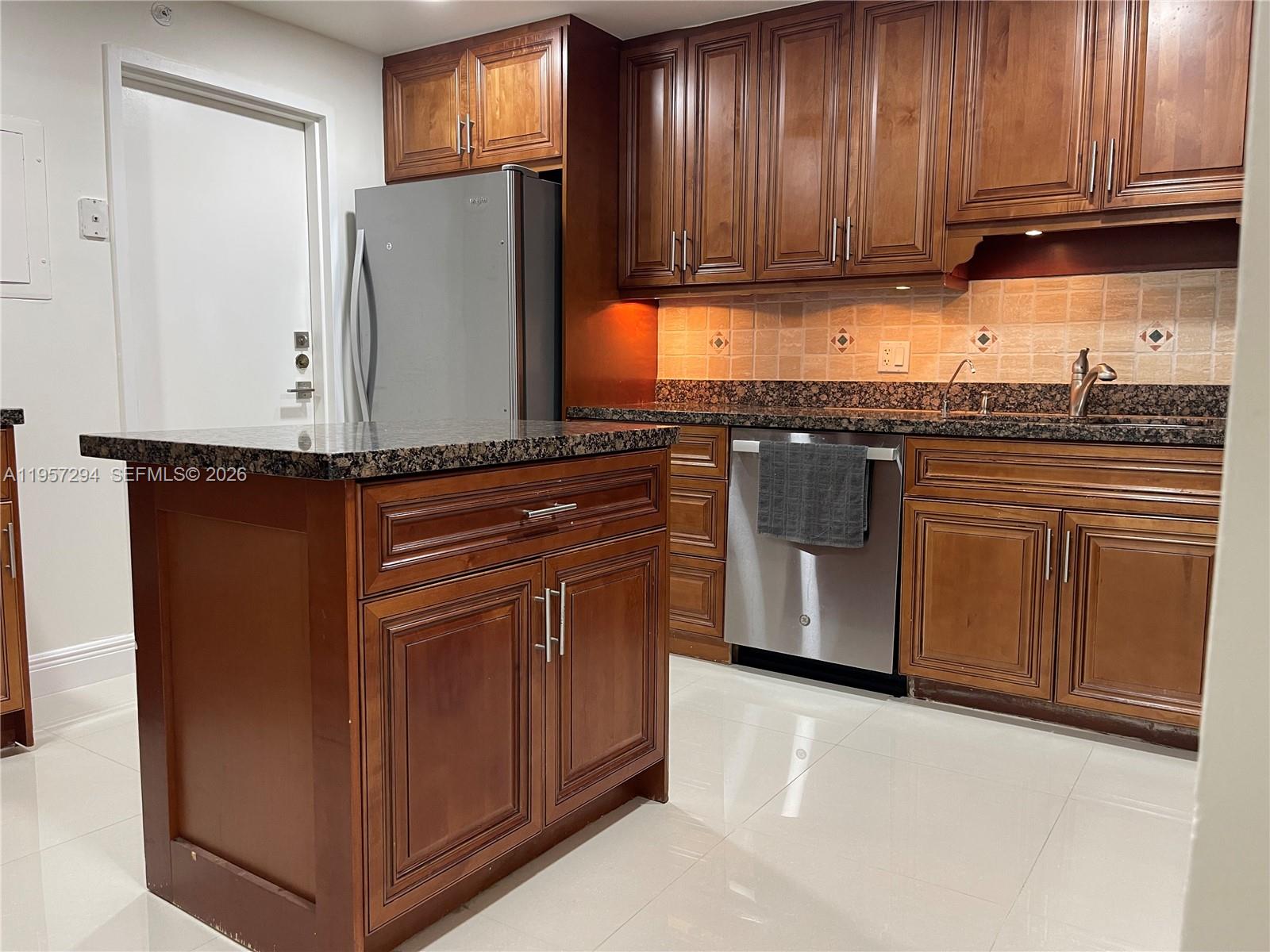 1370 South Ocean Boulevard, Unit 903 Pompano Beach, FL 33062 - Photo 7 of 30 a kitchen with stainless steel appliances granite countertop wooden cabinets a refrigerator and a sink