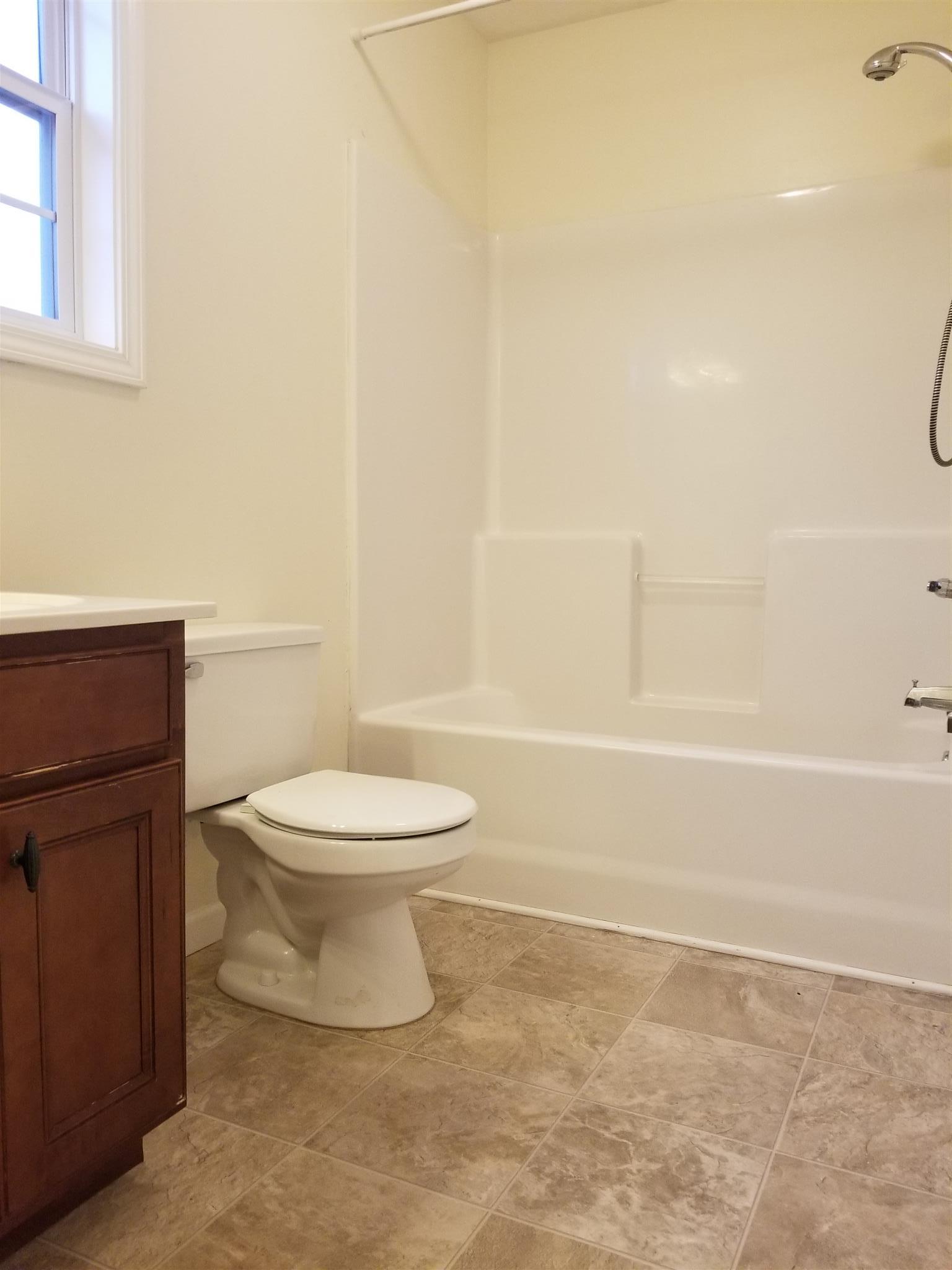 1537 Apache Way Clarksville, TN 37042 - Photo 14 of 19 a white toilet sitting next to a bathroom sink and vanity