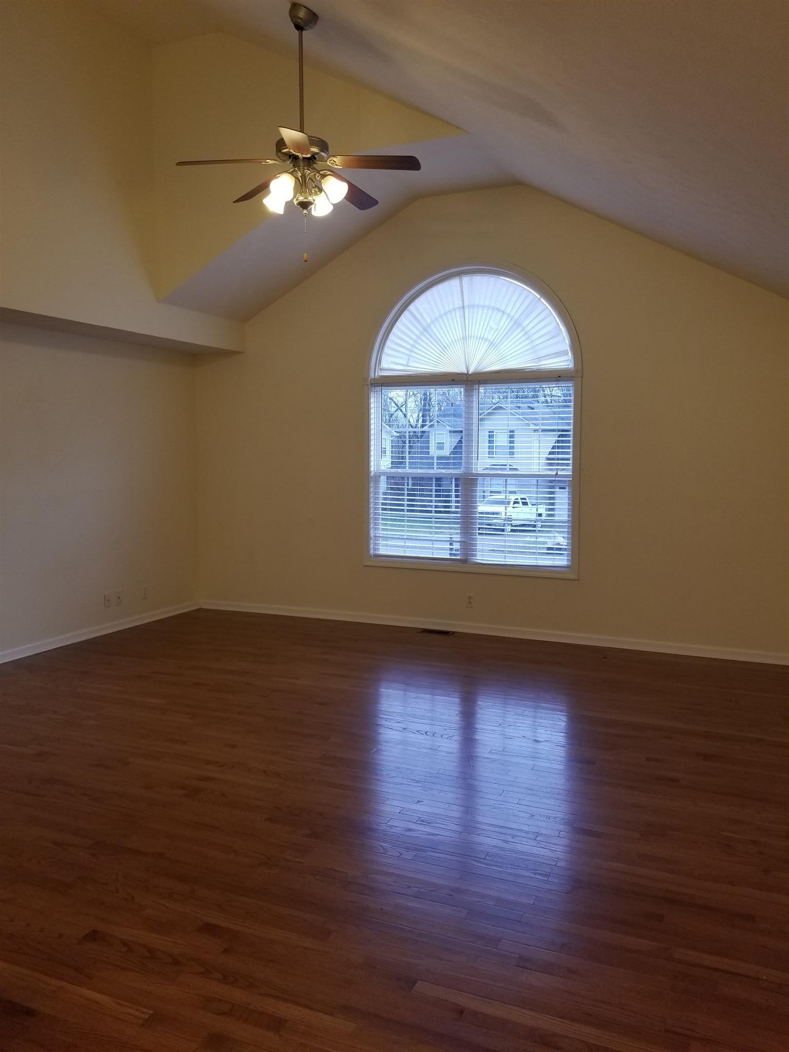 1537 Apache Way Clarksville, TN 37042 - Photo 7 of 19 an empty room with wooden floor chandelier fan and windows