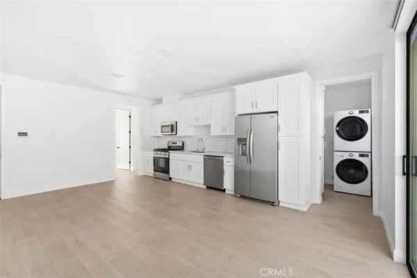 a view of a kitchen with refrigerator and white cabinets