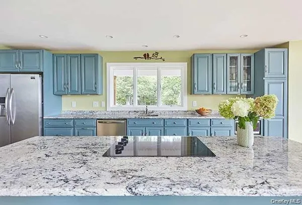 a kitchen with kitchen island granite countertop a sink cabinets and window