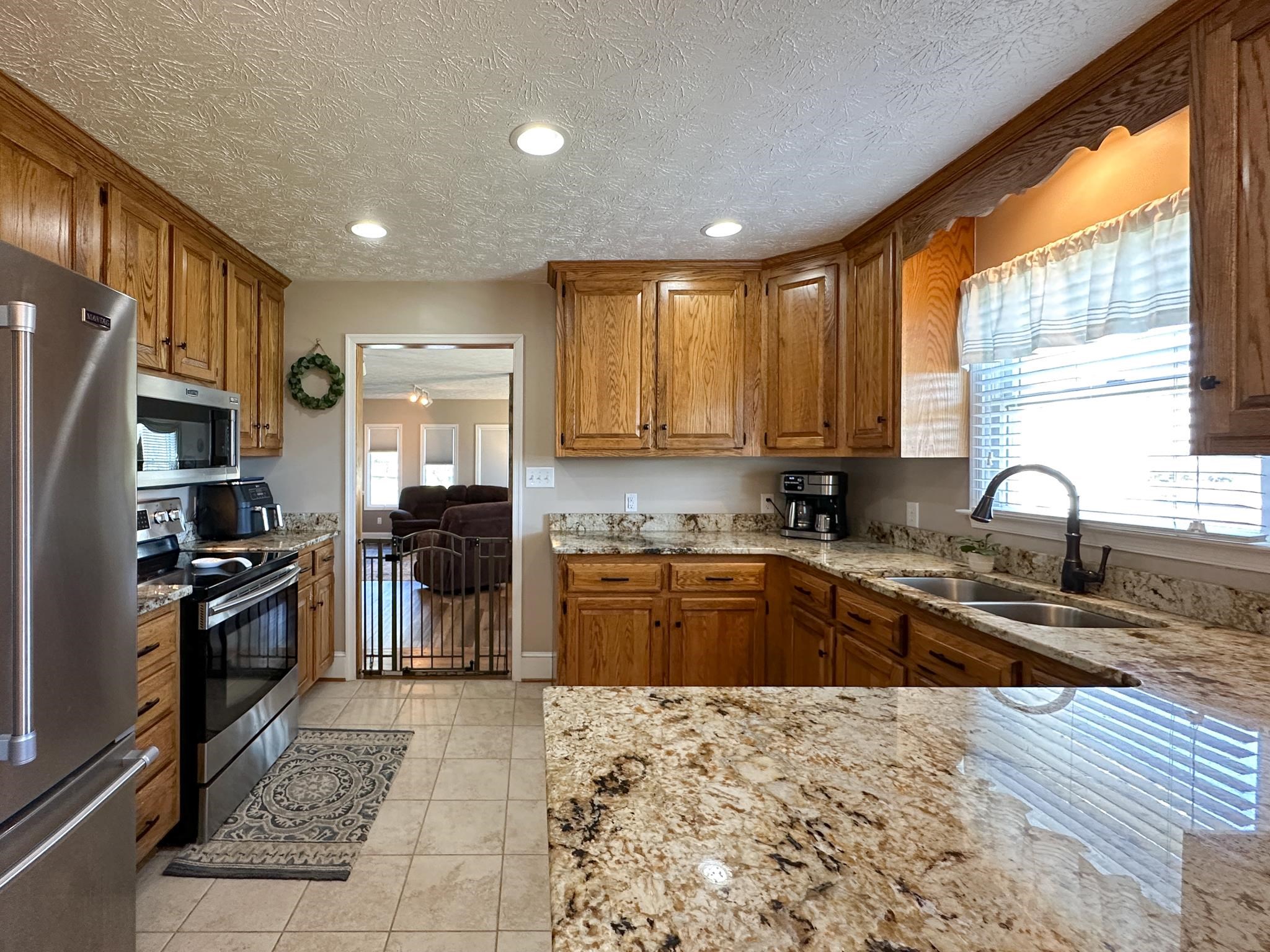 164 Spring Meadows Staunton, VA 24401 - Photo 17 of 37 a kitchen with granite countertop a stove top oven a sink dishwasher a refrigerator and cabinets with wooden floor