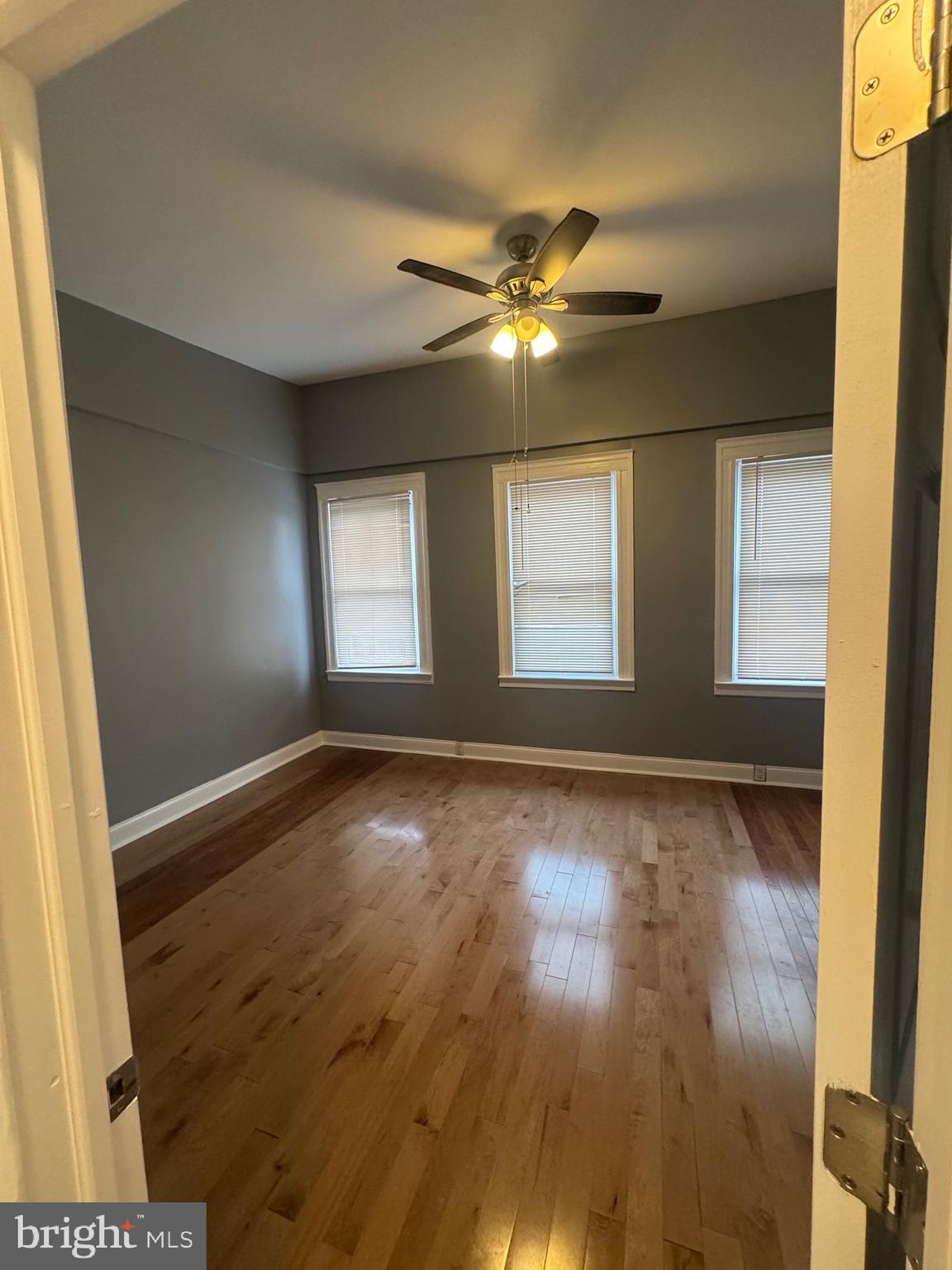 3221 Lyndale Avenue Baltimore, MD 21213 - Photo 12 of 21 a view of an empty room with wooden floor and a window