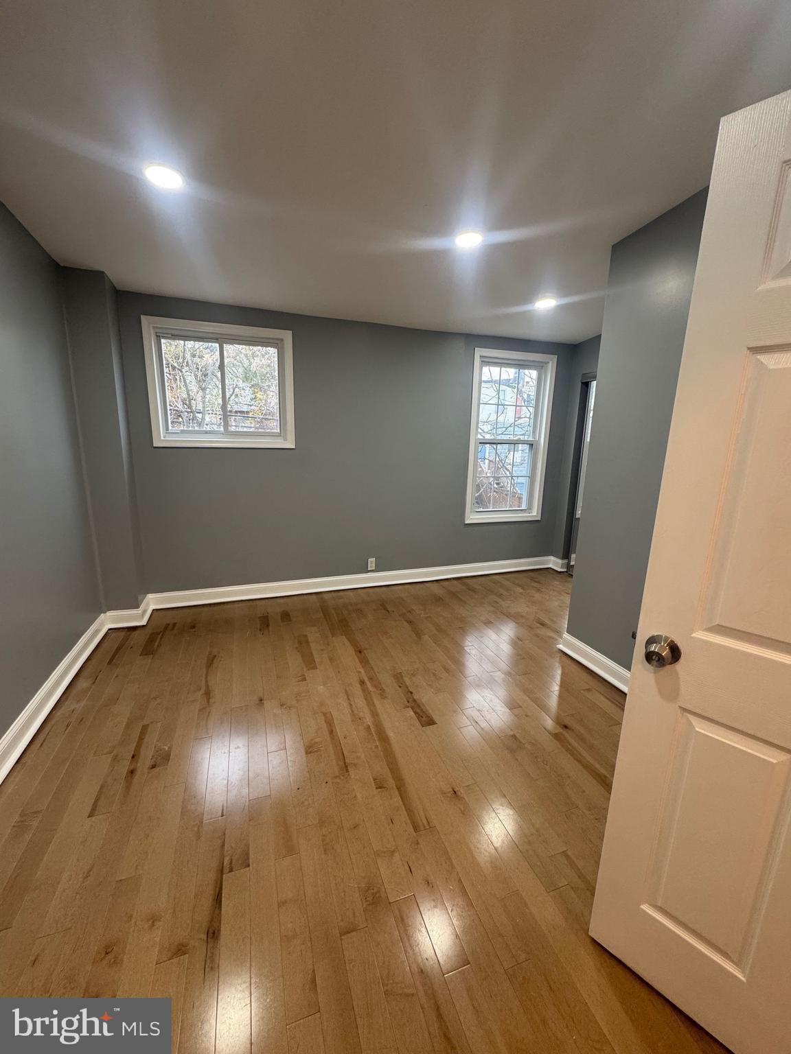 3221 Lyndale Avenue Baltimore, MD 21213 - Photo 10 of 21 a view of an empty room with wooden floor and a window