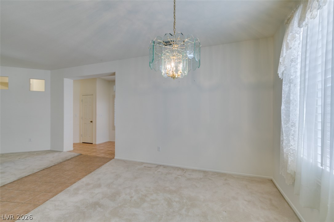 2189 Chapman Ranch Drive Henderson, NV 89012 - Photo 15 of 60 An open doorway connects the carpeted dining area to the tiled entry hall.