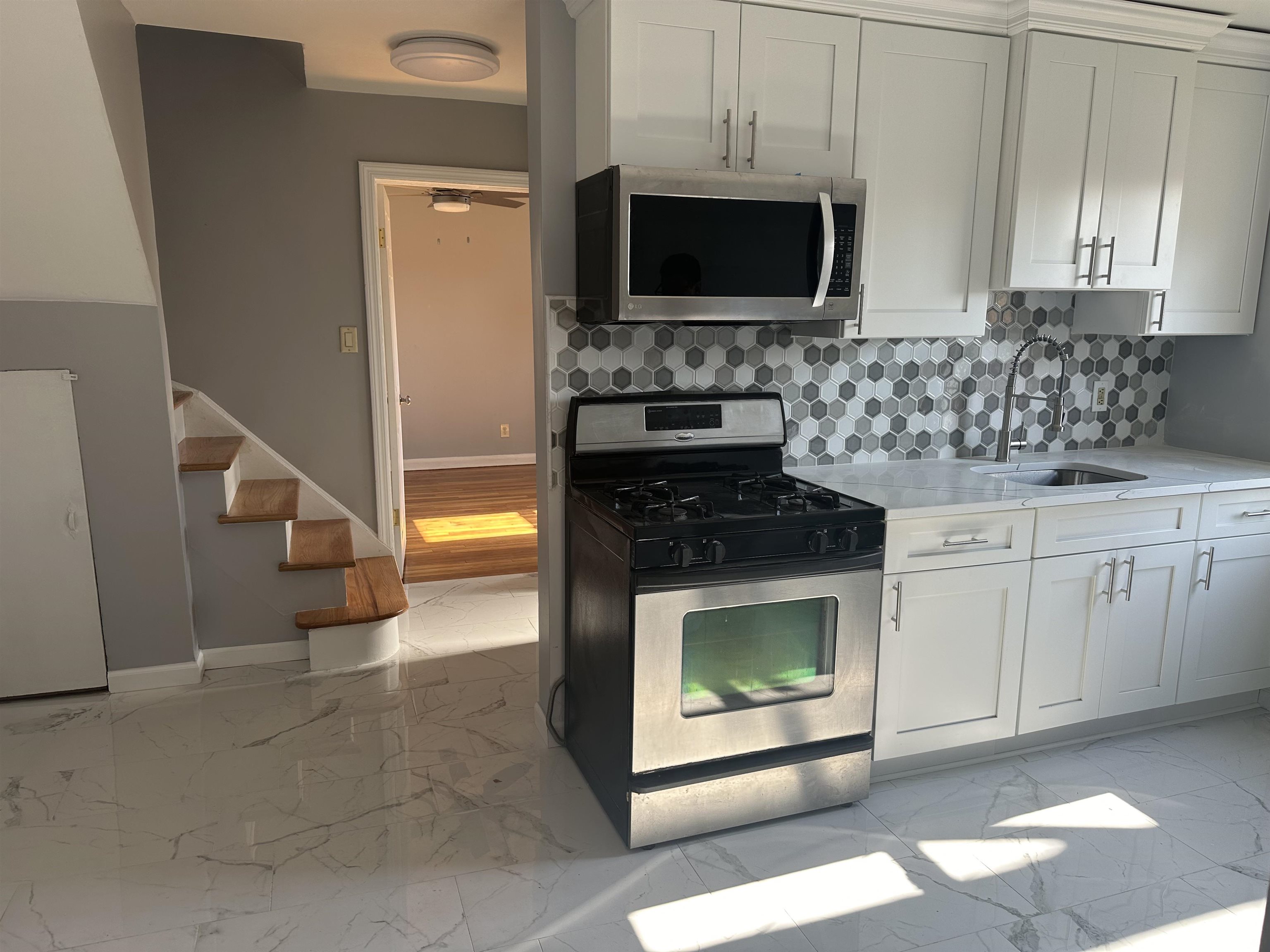 6 Kelly Parkway, Unit 2 Bayonne, NJ 07002 - Photo 1 of 9 a kitchen with stainless steel appliances granite countertop a stove microwave and cabinets