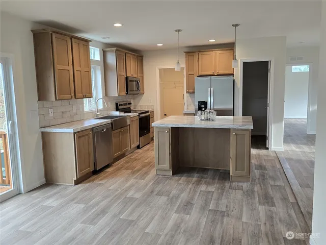 a room with kitchen island a sink dishwasher and wooden floor