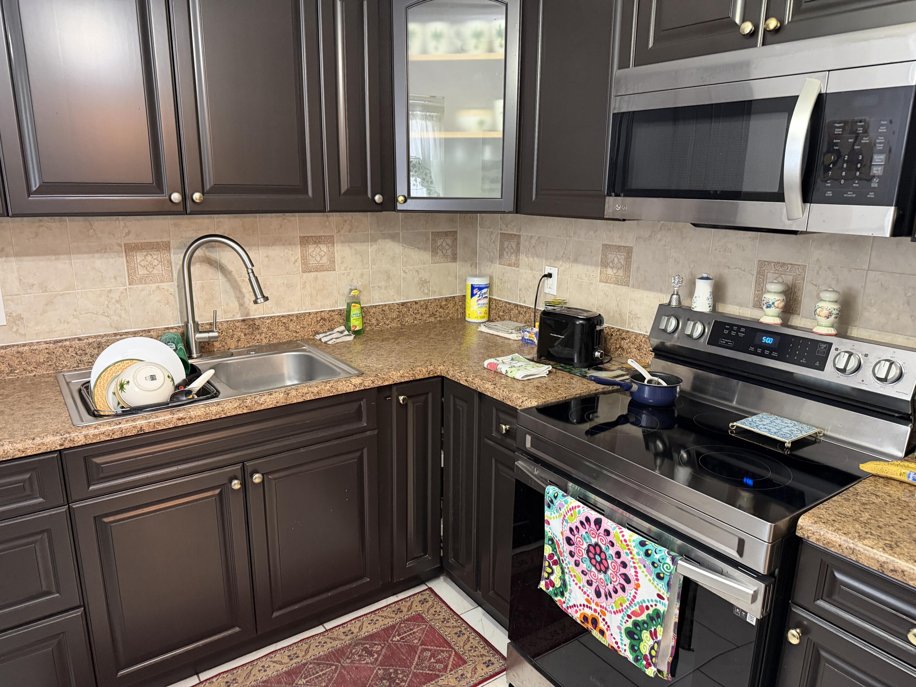 502 Davis Road, Unit 6 Palm Springs, FL 33461 - Photo 7 of 45 a kitchen with granite countertop a sink stainless steel appliances and cabinets
