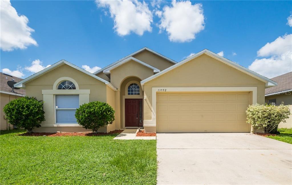 13552 Eyas Road, Unit 4 Orlando, FL 32837 - Photo 1 of 1 a front view of a house with a yard and garage