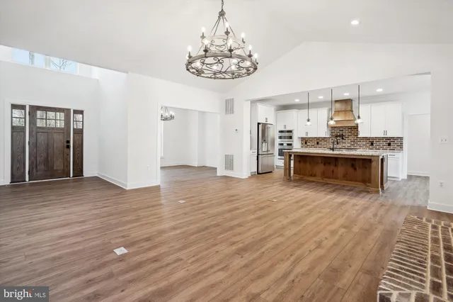 a kitchen with kitchen island white cabinets and stainless steel appliances