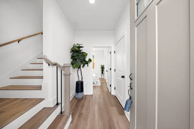 a view of a hallway with wooden floor and staircase