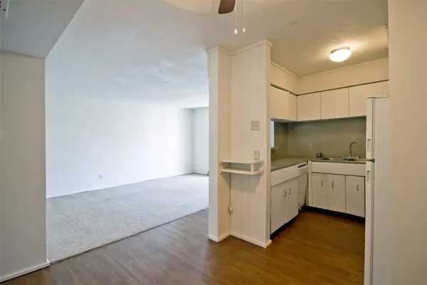 a kitchen with granite countertop white cabinets and white appliances