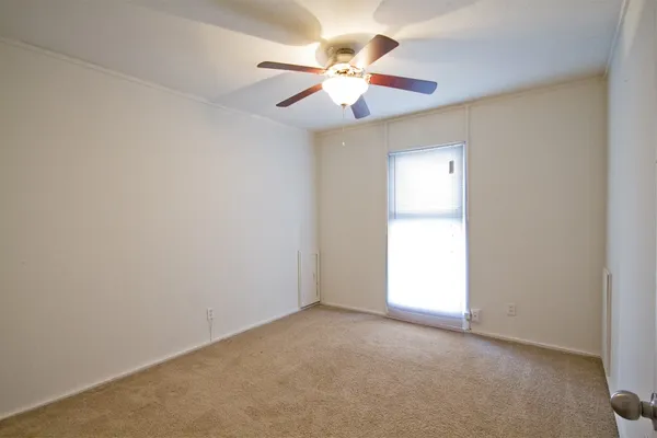 an empty room with closet and a chandelier fan
