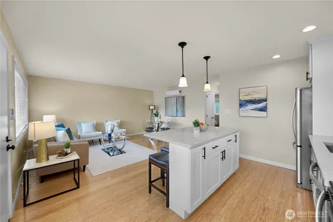 a living room with furniture a flat screen tv and a wooden floor