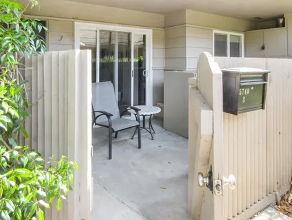 a view of a porch with chairs and potted plants