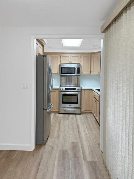 5740 Encina Road, Unit 3 Goleta, CA 93117 - Photo 7 of 29 a view of a kitchen with wooden floor and electronic appliances