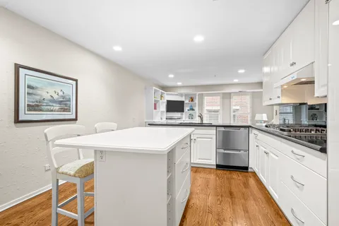 a kitchen with stainless steel appliances kitchen island granite countertop a sink and cabinets