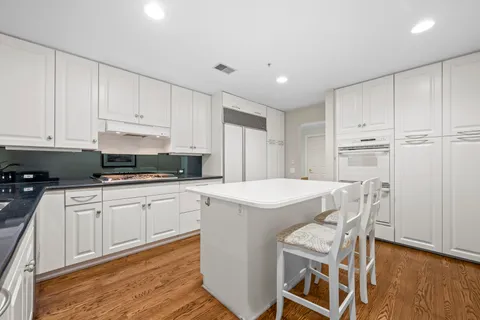 a kitchen with a white table chairs and a refrigerator