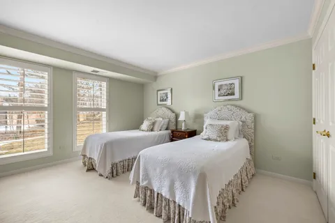 a bedroom with two beds and a large window