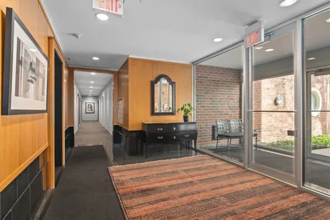 a hallway with a large window dining table and chairs