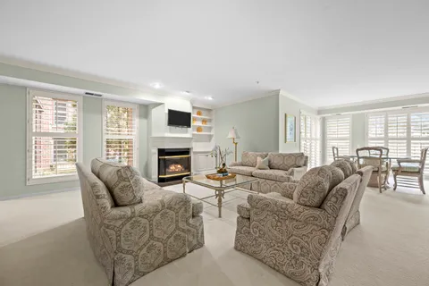 a living room with furniture a large window and a fireplace