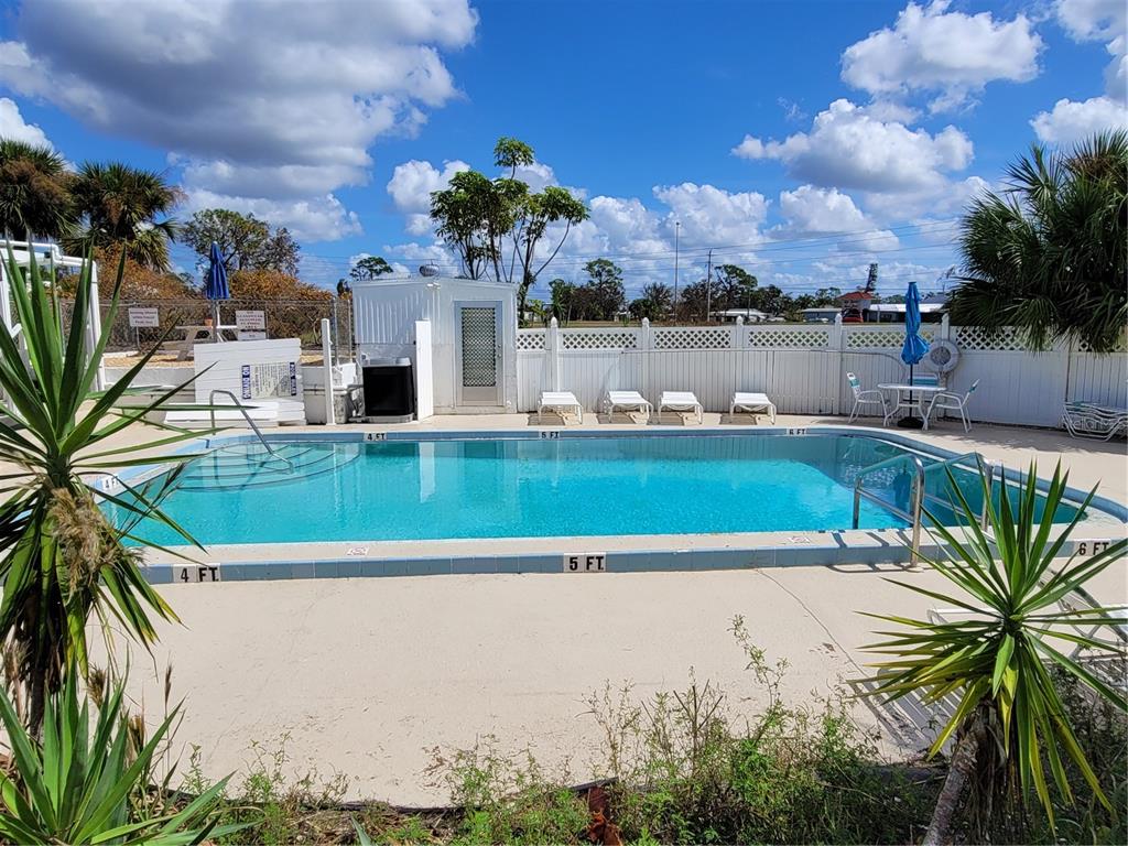 14447 Worthwhile Road Port Charlotte, FL 33953 - Photo 20 of 23 a front view of a house with a garden and lake view