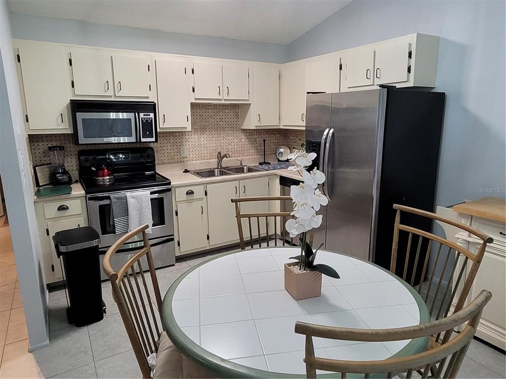 14447 Worthwhile Road Port Charlotte, FL 33953 - Photo 6 of 23 a kitchen with stainless steel appliances granite countertop a refrigerator a stove a sink dishwasher and a refrigerator