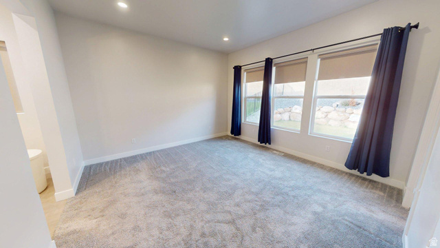 5502 North Valley View Road Lehi, UT 84048 - Photo 10 of 33 Spacious room featuring three large windows, recessed ceiling lighting, light gray wall finishes, and gray carpet flooring