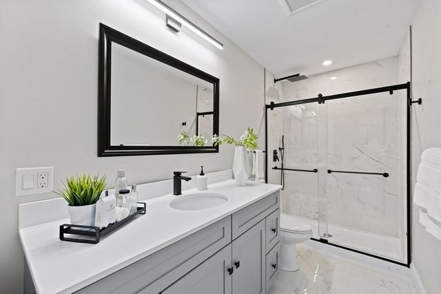 a spacious bedroom with a bed and a double vanity sink