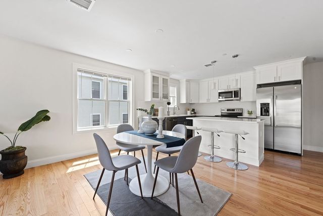 a kitchen with granite countertop white cabinets and stainless steel appliances