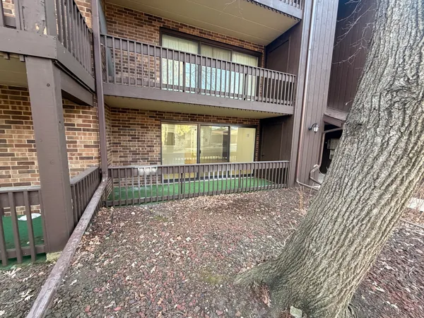 a view of a brick house with large windows and a small yard
