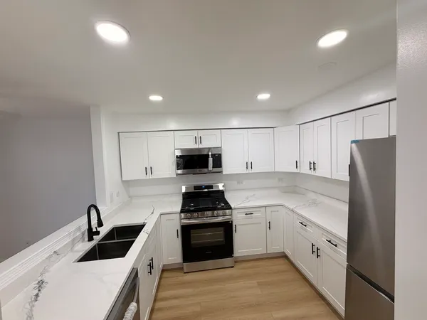 a kitchen with white cabinets and stainless steel appliances