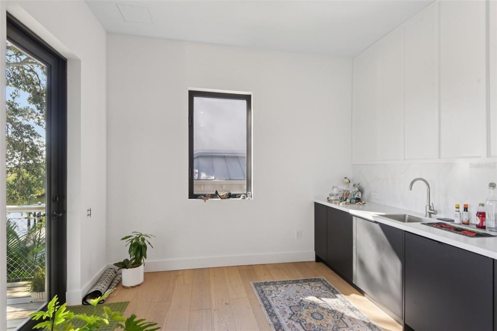 4828 West Flamingo Road Tampa, FL 33611 - Photo 21 of 67 a room with a wooden floor and a potted plant