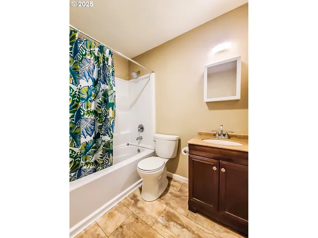 a bathroom with a granite countertop toilet and a sink