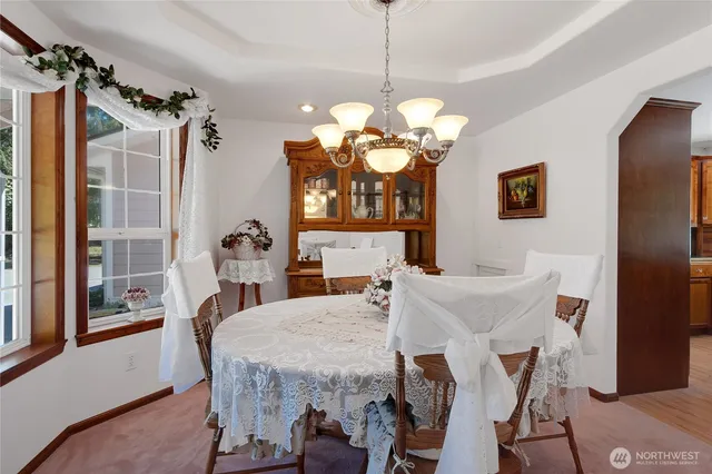 a view of a dining room with furniture a chandelier and wooden floor