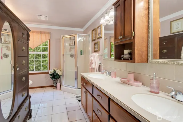 a spacious bathroom with a double vanity sink a mirror a and a shower