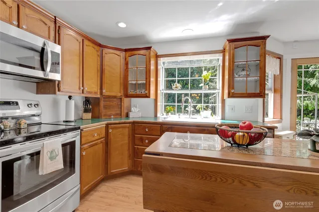 a kitchen with stainless steel appliances granite countertop a sink and a stove