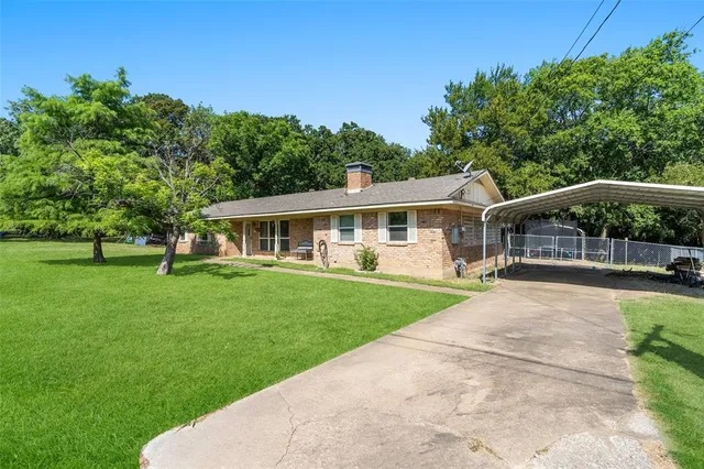 a view of a house with backyard and sitting area