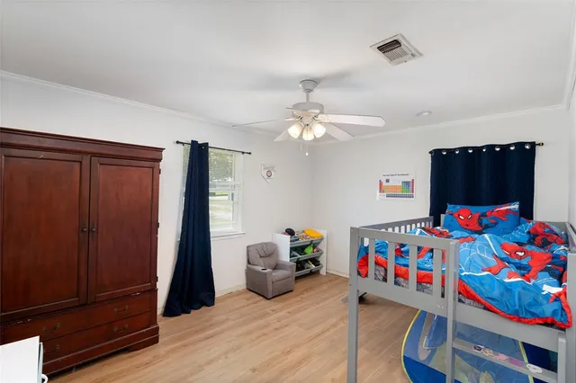 a bedroom with baby crib and a window