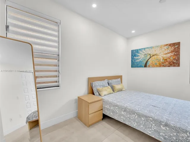 a bedroom with a bed and painting on the wall