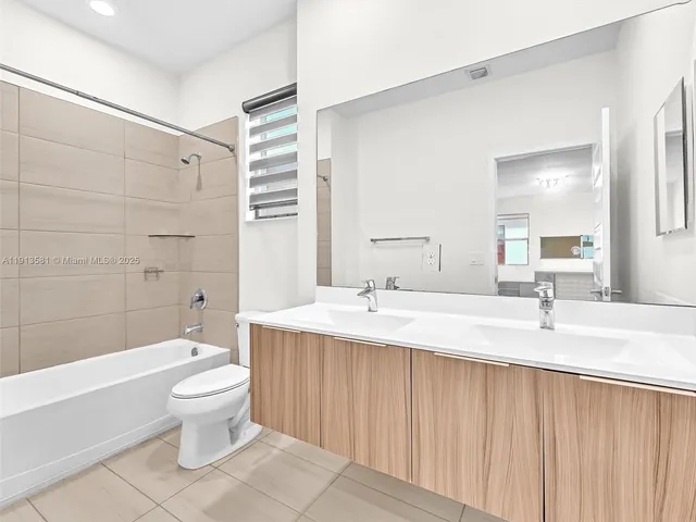 a white bed sitting in a room next to a window