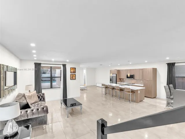 a living room with furniture kitchen view and a table